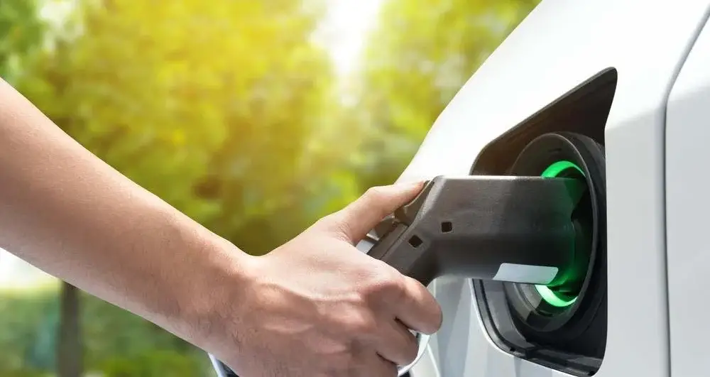 Image of an ev charger being connected to a car
