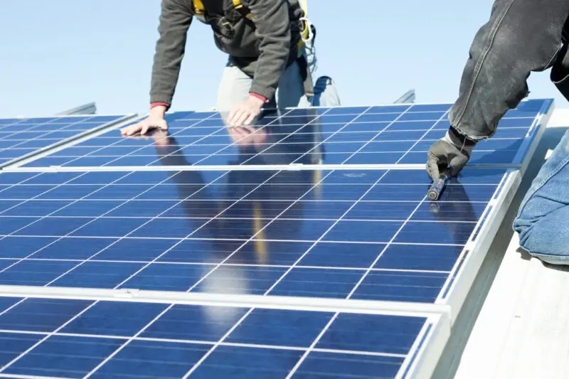Image of workers installing rooftop solar panels